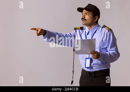 Portrait of security guard pointing away with index finger Stock Photo