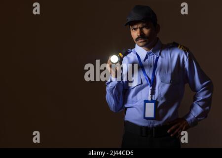 Security guard searching with torch light while working at night Stock Photo