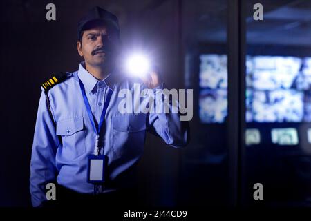 Security guard searching with torch light while working at night Stock Photo