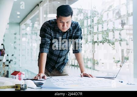 Engineers are designing working on blueprints and analyzing the structure of the project. Stock Photo