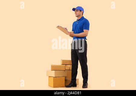 Portrait of a courier delivery boy writing on clipboard Stock Photo