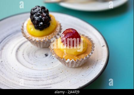 Two mini fruit italian cupcakes with fresh berries on board Stock Photo