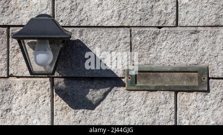 Mailbox hatch and light bulb. Block wall or fence. Stock Photo
