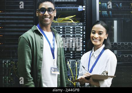 No virus, no problem. Shot of two technicians working together in a server room. Stock Photo
