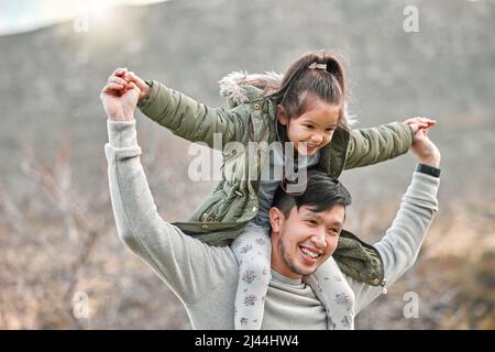Were going on an adventure. Shot of a man carrying his daughter on his shoulders. Stock Photo
