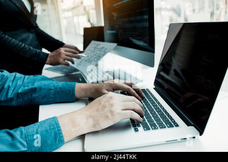 Two partnerships developing programming and coding technologies working on laptop and analyzing together. Stock Photo