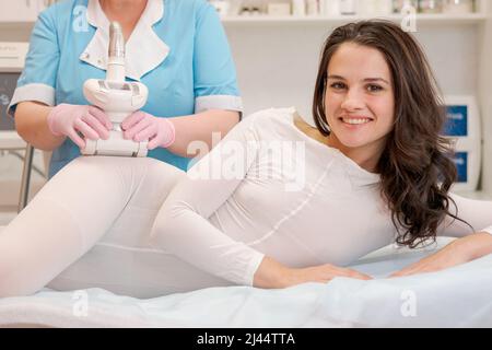 Lifting body. Beautiful woman is receiving an LPG massage to remove cellulite from her body. Anti-cellulite massage with LPG Massager. Beautiful slim body, skin stretch marks and cellulite removal Stock Photo