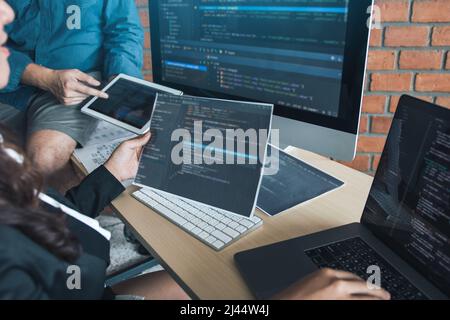 Two software developers are analyzing together about the code written into the program on the computer. Stock Photo