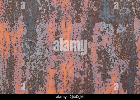 Rusting metal surface. Texture of worn and rusty metal surface with remains of several layers of red paint, high resolution. Stock Photo