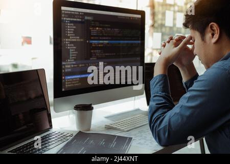 Software developers headache with code analysis in the office. Stock Photo