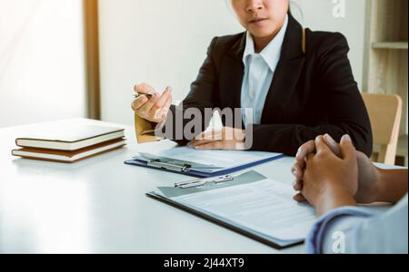 Asian young adult sitting at desk across from manager being interviewed job interview in business room. Stock Photo