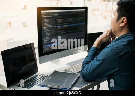 Asian man working code program developer computer web development working design software on desk in office. Stock Photo