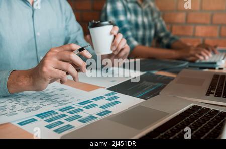 Working in the morning with businessmen are dipping coffee that works with software developers to analysis together the code written in the program on Stock Photo