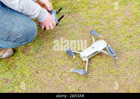 young man flying and controlling DJI magic drone Stock Photo