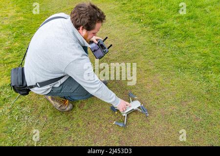 young man flying and controlling DJI magic drone Stock Photo