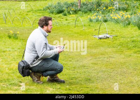 young man flying and controlling DJI magic drone Stock Photo