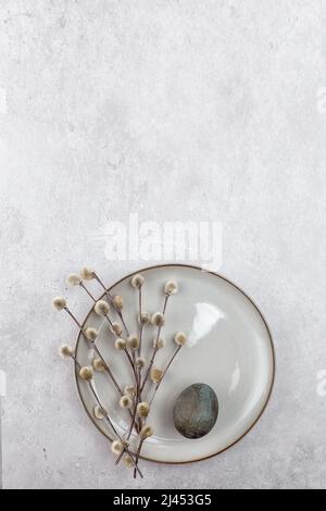 Easter picture with painted eggs on a plate. Willow branch. The minimal concept of Easter. An Easter card with a place for the text. Stock Photo