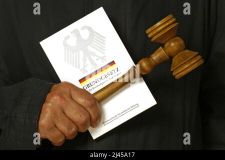 Ein Richter hält das Grundgesetz in den Händen, Buch, Richterhammer, Stock Photo