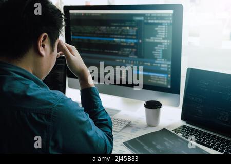 Software developers headache with code analysis in the office. Stock Photo