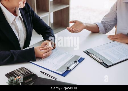 Asian young adult sitting at desk across from manager being interviewed job interview in business room. Stock Photo