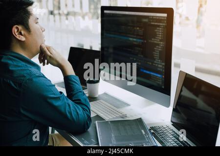 Asian man working code program developer computer web development working design software on desk in office. Stock Photo