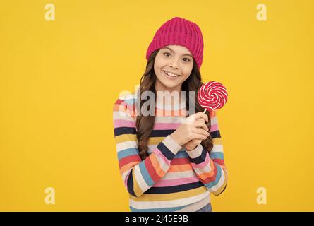 lollipop lady. hipster kid with colorful lollypop sugar candy on stick. caramel candy shop. Stock Photo