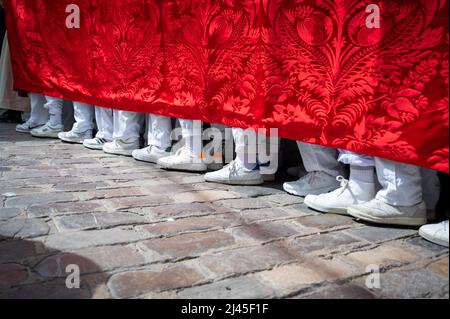 Cadiz, Spain. 11th Apr, 2022. The feet of the men carrying a heavy throne as people take part in the traditional Semana Santa or Holy Week parades in Cadiz Spain. Everyday this week the Brotherhoods engage in spectacular processions and marching bands around the city leading huge thrones depicting Jesus on the cross and the Virgin Mary. Many wear traditional robes and high pointed hats. Credit: Julian Eales/Alamy Live News Stock Photo