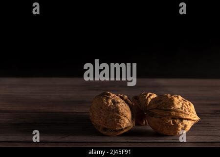 walnuts on top of wooden table with black background. Stock Photo