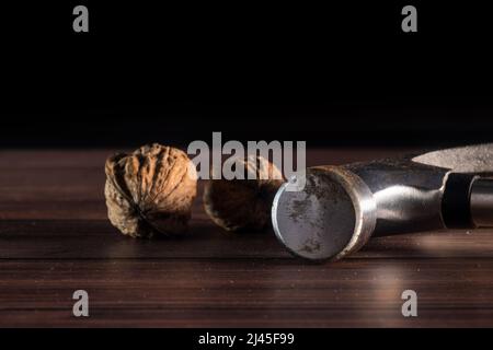 walnuts on top of wooden table with martel, with black background. Stock Photo
