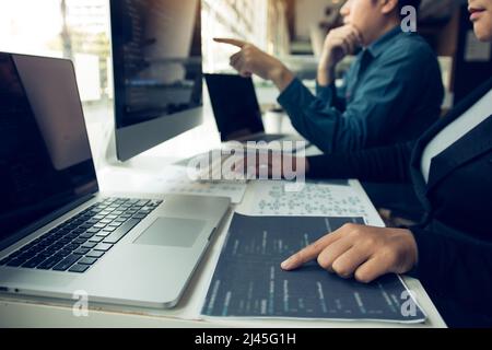 Two software developers are analyzing together about the code written into the program on the computer. Stock Photo