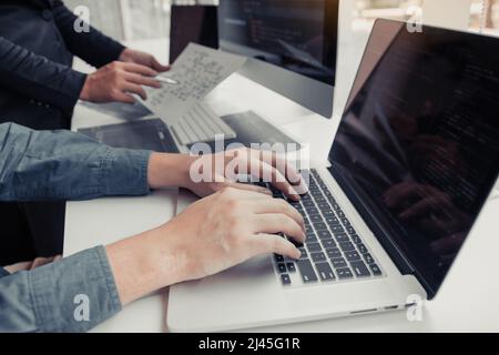 Two partnerships developing programming and coding technologies working on laptop and analyzing together. Stock Photo