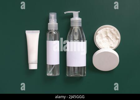 Homemade Cosmetics in plastic tubes and bottles on dark green top view. Brand packaging mockup. Organic natural cosmetics for skin and hair care Stock Photo