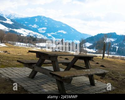 Wooden picnic table with benches in the rest area off highway with mountains in the background. Salzburg, Upper Austria.