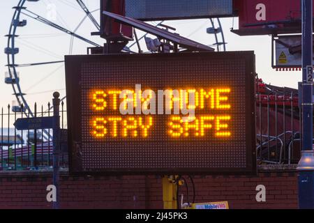 Transportable illuminated sign at Barry Island during Covid 19 pandemic. Message 'stay home stay safe'. Stock Photo
