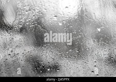 Close the misted glass with water drops flowing down. Dripping condensation, drops of water. Background Raindrop.Texture Stock Photo