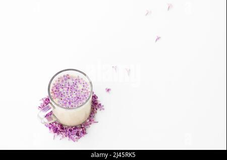 Cup of hot morning coffee and lilac petals on a white background. Copy space for text. Concept of holidays and good morning wishes. Stock Photo