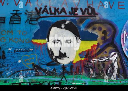 Russian president Vladimir Putin depicted on the Lennon Wall (Lennonova zeď) in Prague, Czech Republic, pictured on 2 April 2022. President Vladimir Putin is depicted with characteristic haircut and toothbrush mustache of Adolf Hitler placed on the blooded map of Ukraine to protest against the Russian invasion of Ukraine in 2022. The Czech inscription over the Putin's head 'Válka je vůl' (Literary means: War is an ox) is a line from a popular song of Czech rock band 'Synkopy 61'. Stock Photo