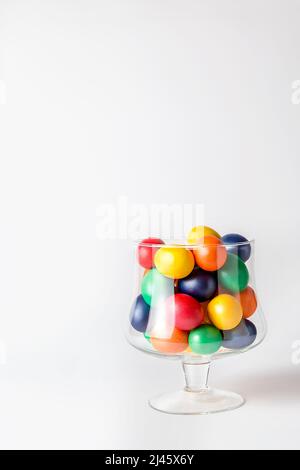 Multicolored painted eggs in a glass vase. Easter concept. A ready place for your invitation text, congratulations. Stock Photo