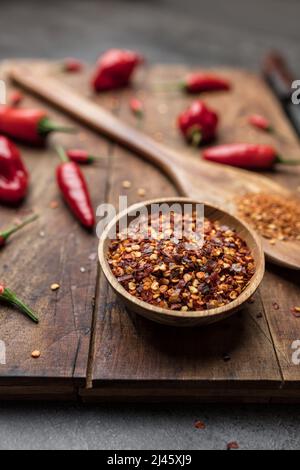 Variety of fresh and dried chili peppers on rustic background Stock Photo