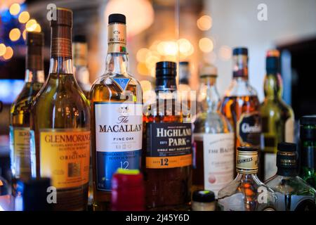 Various bottles of alcoholic beverages on the shelf in the bar Stock Photo