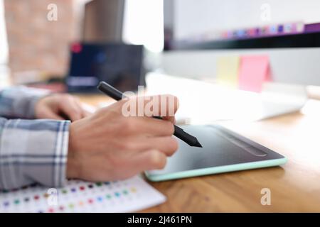 Stylus in hand from graphics tablet closeup Stock Photo