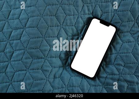 Smartphone mockup white screen on bed duvet cover, top view Stock Photo