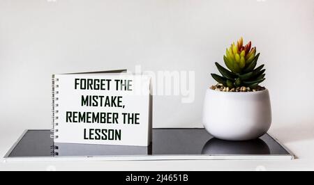 Text Forget about the mistake, remember the lesson on the notebook. Inspirational and motivational quote concept. Stock Photo