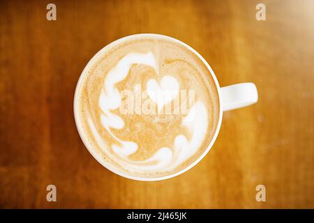How lovely. High angle shot of a cup of coffee on a table in a coffee shop. Stock Photo