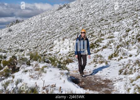 A Female traveler standing on snowy mount Stock Photo