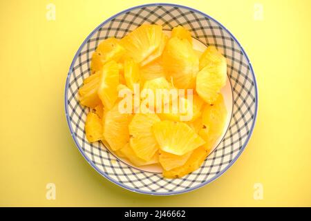 slice of pineapple in bowl on blue background  Stock Photo