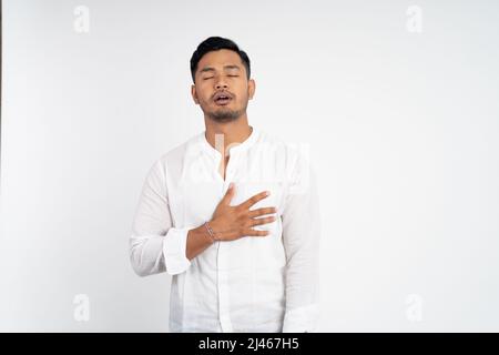 calm man with chest hands while feeling comfortable and relieved Stock Photo