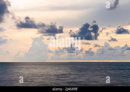 the landscape is the sea and clouds calmly and majestically floating above it. evening sunset in cold blue tones. Stock Photo