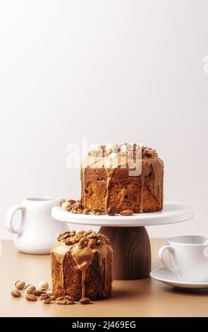 Caramel glazed Easter cakes decorated with nuts on pastel background. Easter composition with cakes closeup. Easter background with copy space for your design. Stock Photo
