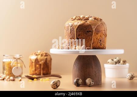 Caramel glazed Easter cakes decorated with nuts on pastel background. Easter composition with cakes, nuts, raisins and quail eggs. Easter background with copy space for your design. Stock Photo